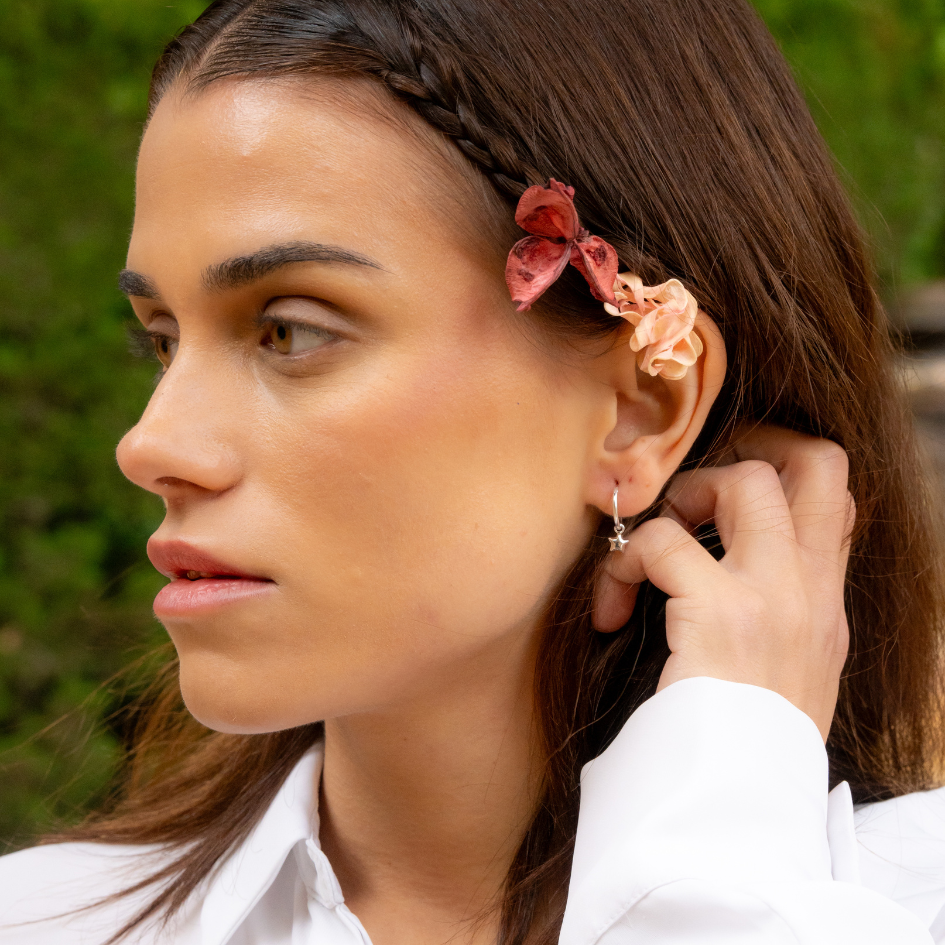 Sterling silver star huggie hoop earrings styled in outdoor setting – intentional, soft presence look