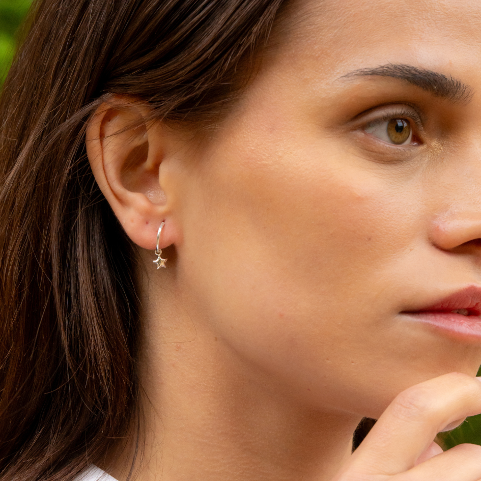 Side profile of model wearing sterling silver star huggie hoops – minimalist everyday jewelry