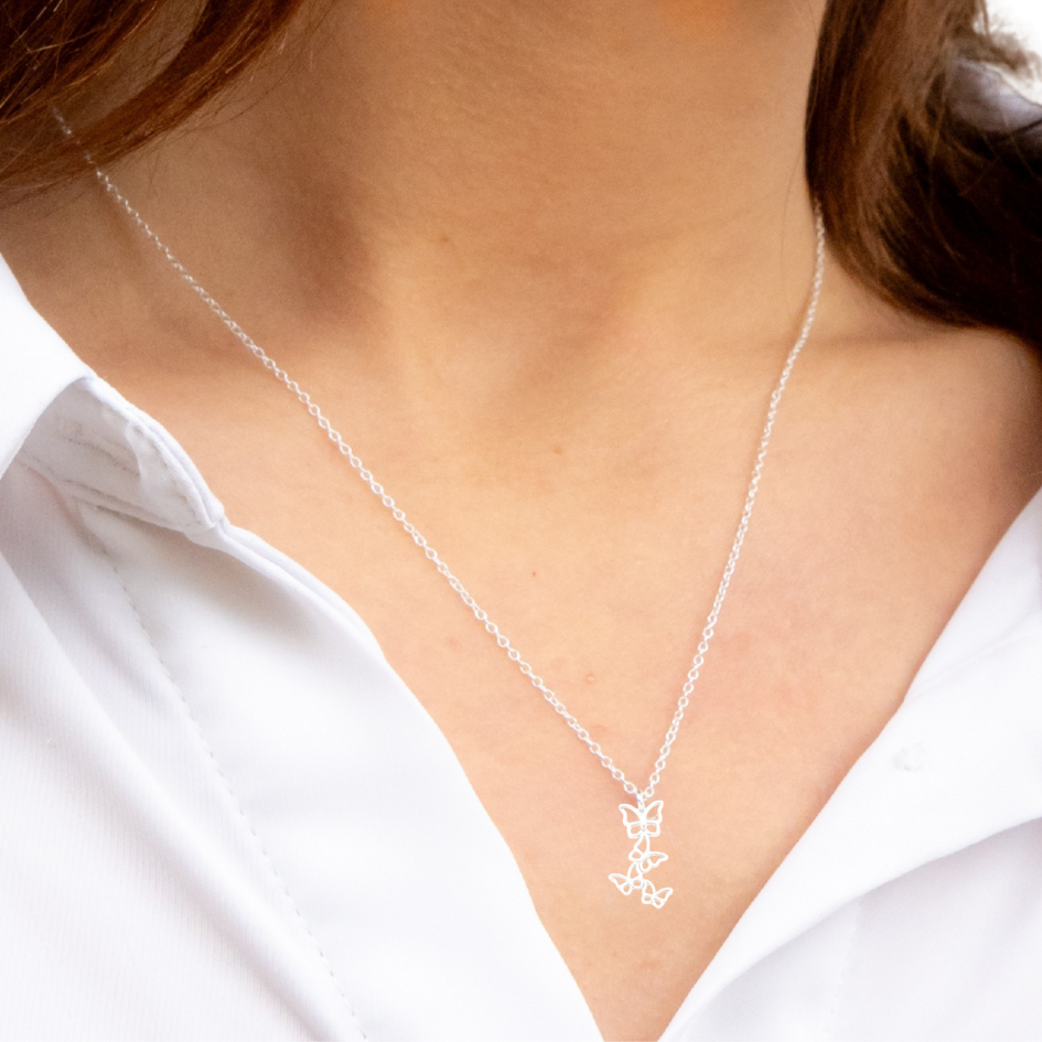 Model wearing sterling silver necklace with floating butterfly pendant, silver butterfly necklace detail visible.